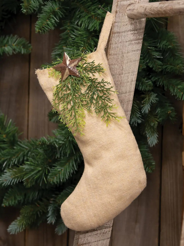 natural fabric stocking with winter greenery and rusty star