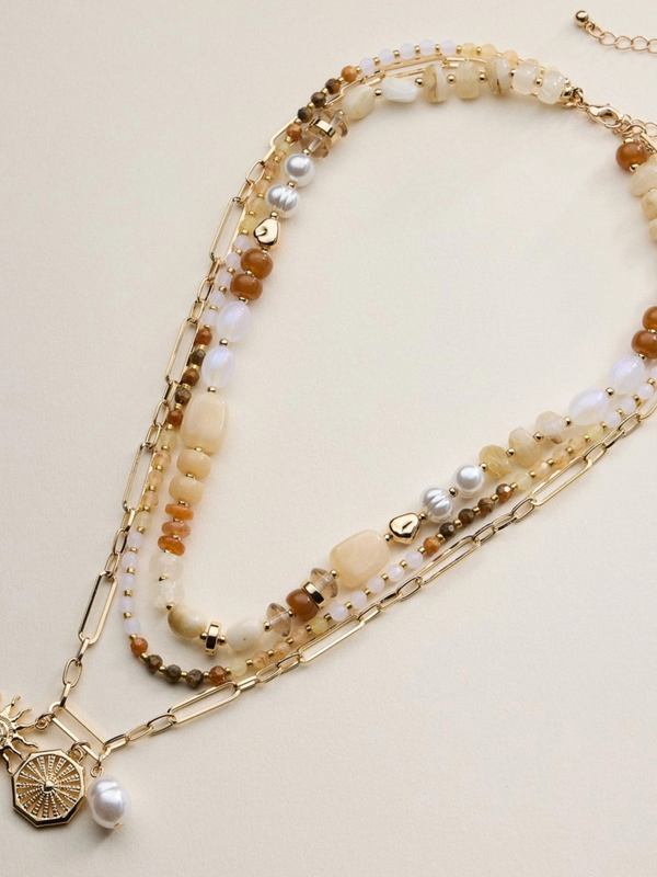 neutral layered beaded and chain necklace with sun and pearl charms