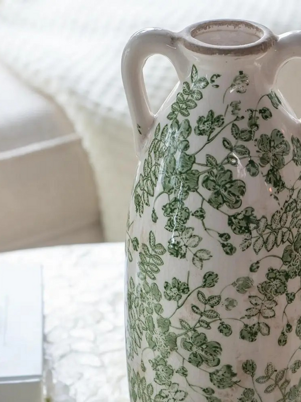 white ceramic vase with green florals and handles