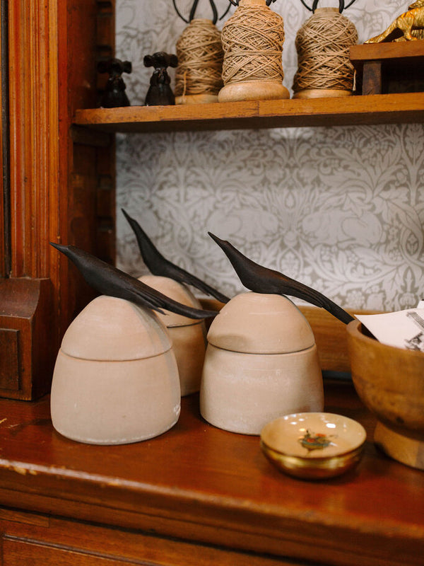 large clay canister with wood bird handle