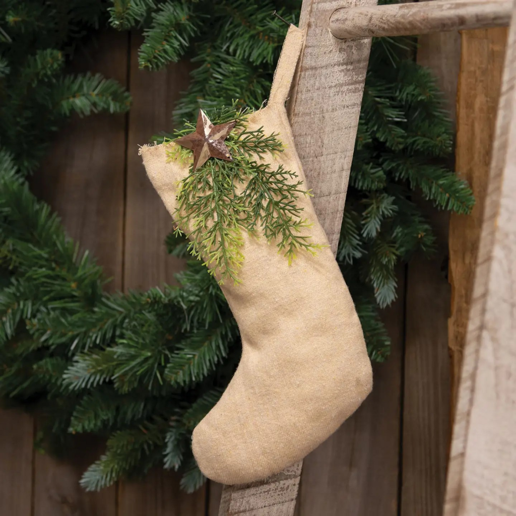 natural fabric stocking with winter greenery and rusty star