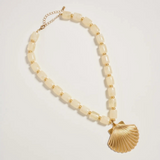 neutral chunky beaded necklace with large gold seashell pendant