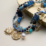 blue layered beaded and chain necklace with sun and pearl charms