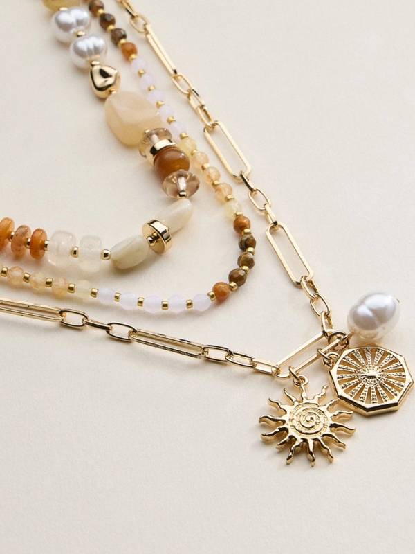 neutral layered beaded and chain necklace with sun and pearl charms