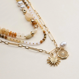 neutral layered beaded and chain necklace with sun and pearl charms