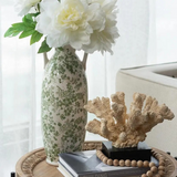 white ceramic vase with green florals and handles