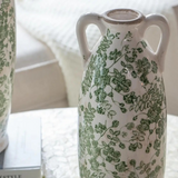 white ceramic vase with green florals and handles