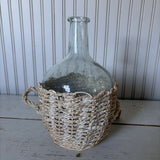 glass bottle in woven basket